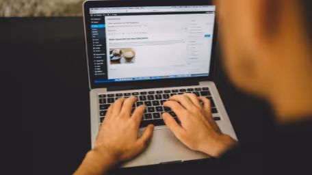 Person typing a blog post on WordPress