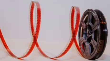 Film reel unspooling on a white surface