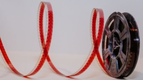 Film reel unspooling on a white surface