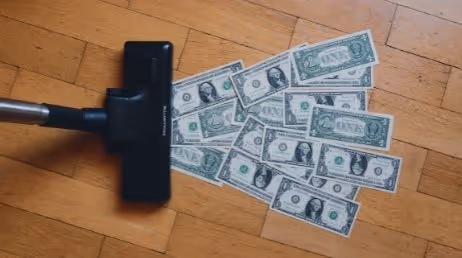 Vacuum cleaner with dollar bills on floor