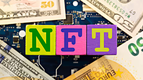 NFT letters on colorful blocks with dollar bills