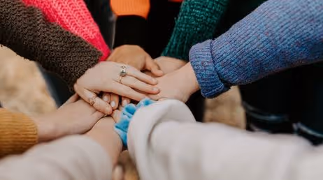 Group of hands coming together in teamwork