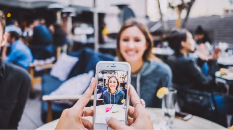 Woman's photo being taken by a friend at a cafe