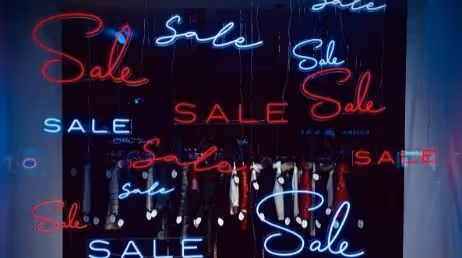 Sale neon signs in a storefront window