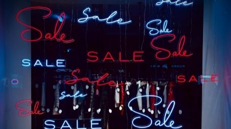 Sale neon signs in a storefront window