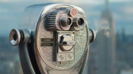 Vintage coin-operated binocular viewer with city background
