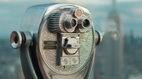Vintage coin-operated binocular viewer with city background