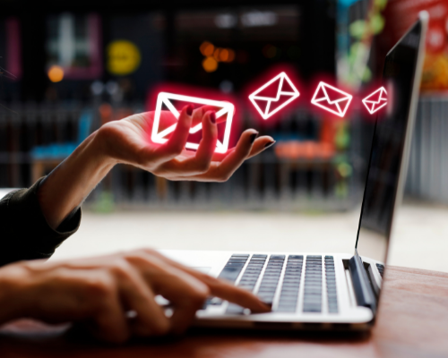 User interacting with a laptop and sending emails