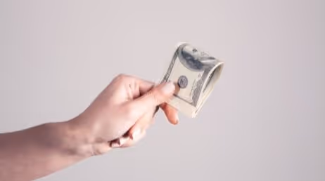 Person holding a dolor currency note in hand