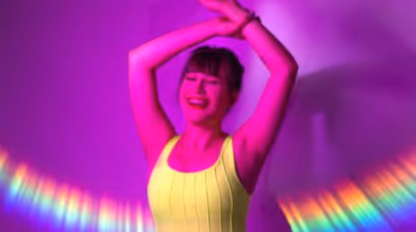 Woman dancing in neon lighting with vibrant colors