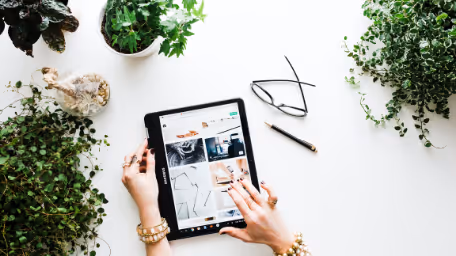 Using tablet with plants on a white desk