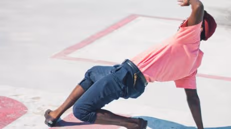 Breakdancer in pink shirt performing on street