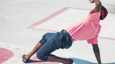 Breakdancer in pink shirt performing on street