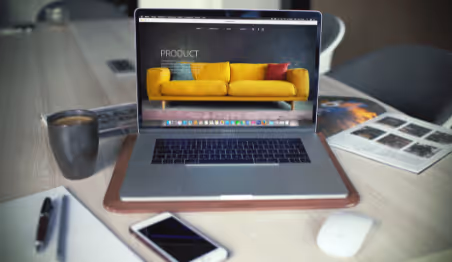 Open laptop displaying product webpage with yellow sofa design
