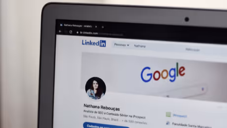 LinkedIn profile page open on a laptop with Google search