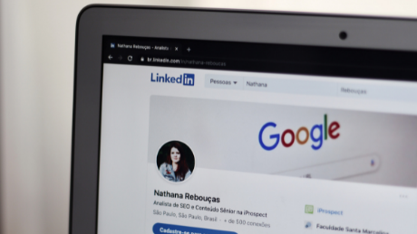 LinkedIn profile page open on a laptop with Google search