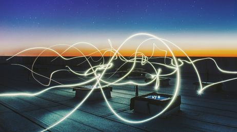 Abstract light trails on rooftop at dusk