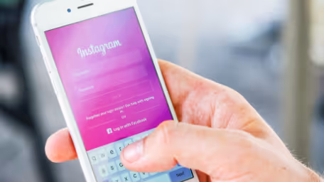 Hand holding phone with Instagram login screen