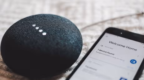 Smart speaker with phone displaying home automation app