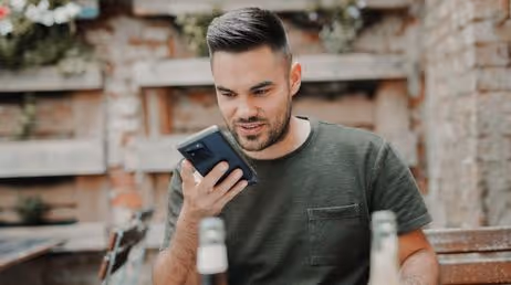 Man using voice command on smartphone outdoors