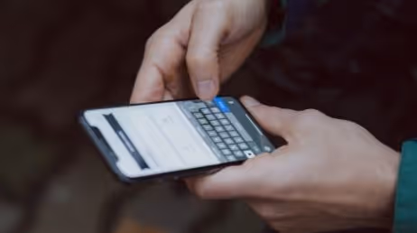 Person typing on smartphone screen
