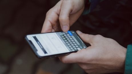 Person typing on smartphone screen