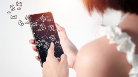 Person using phone with email icons overlay