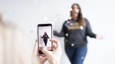 Person recording a video of woman with confetti"