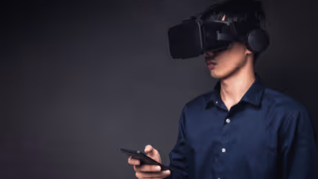 Person using VR headset and smartphone