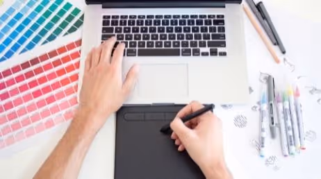 Graphic designer working on laptop with color palett