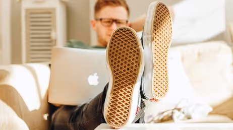 Person relaxing with feet up while working on a laptop