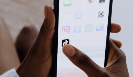 Person holding phone with TikTok app on screen