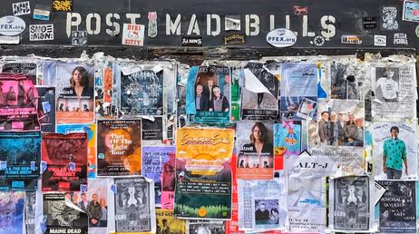 Colorful posters covering a public wall