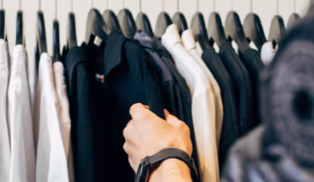 Person selecting clothes from a clothing rack