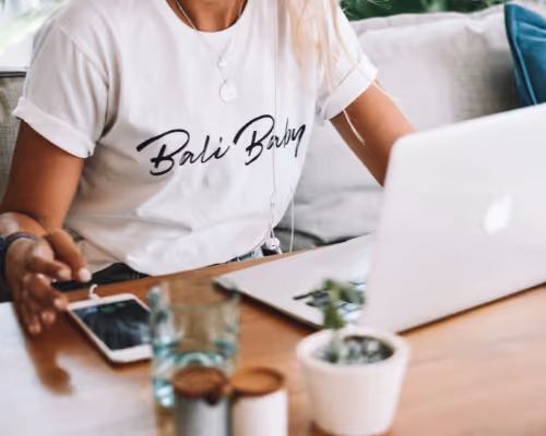 Person working on laptop with Bali Babe t-shirt