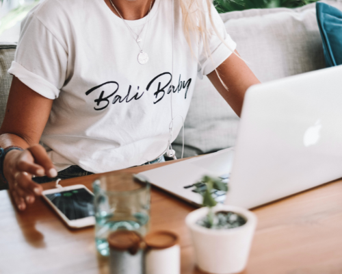 Person working on laptop with Bali Babe t-shirt