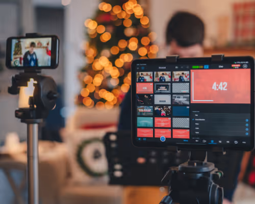 Person recording holiday livestream with tablet and smartphone setup