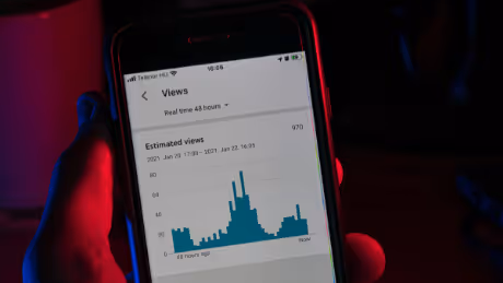 Person viewing YouTube real-time analytics on phone