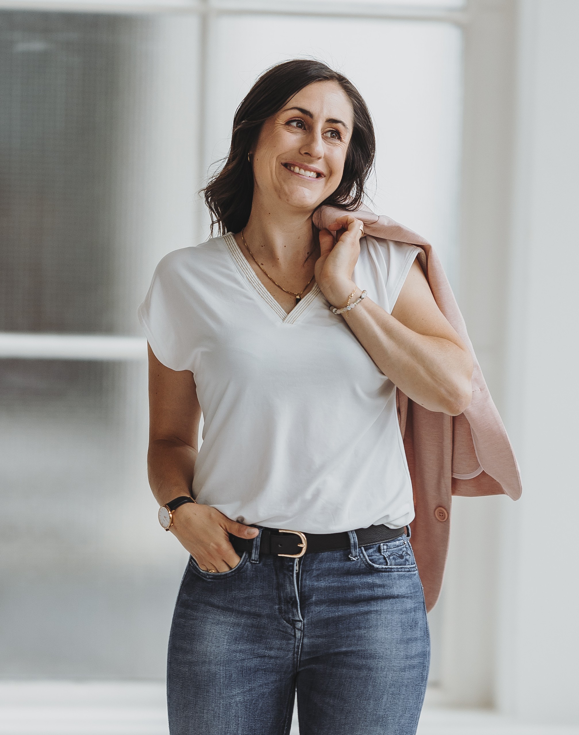 Sandra Wettstein mit weissem T-Shirt und Jeans trägt rosa Jacke über der Schulter.