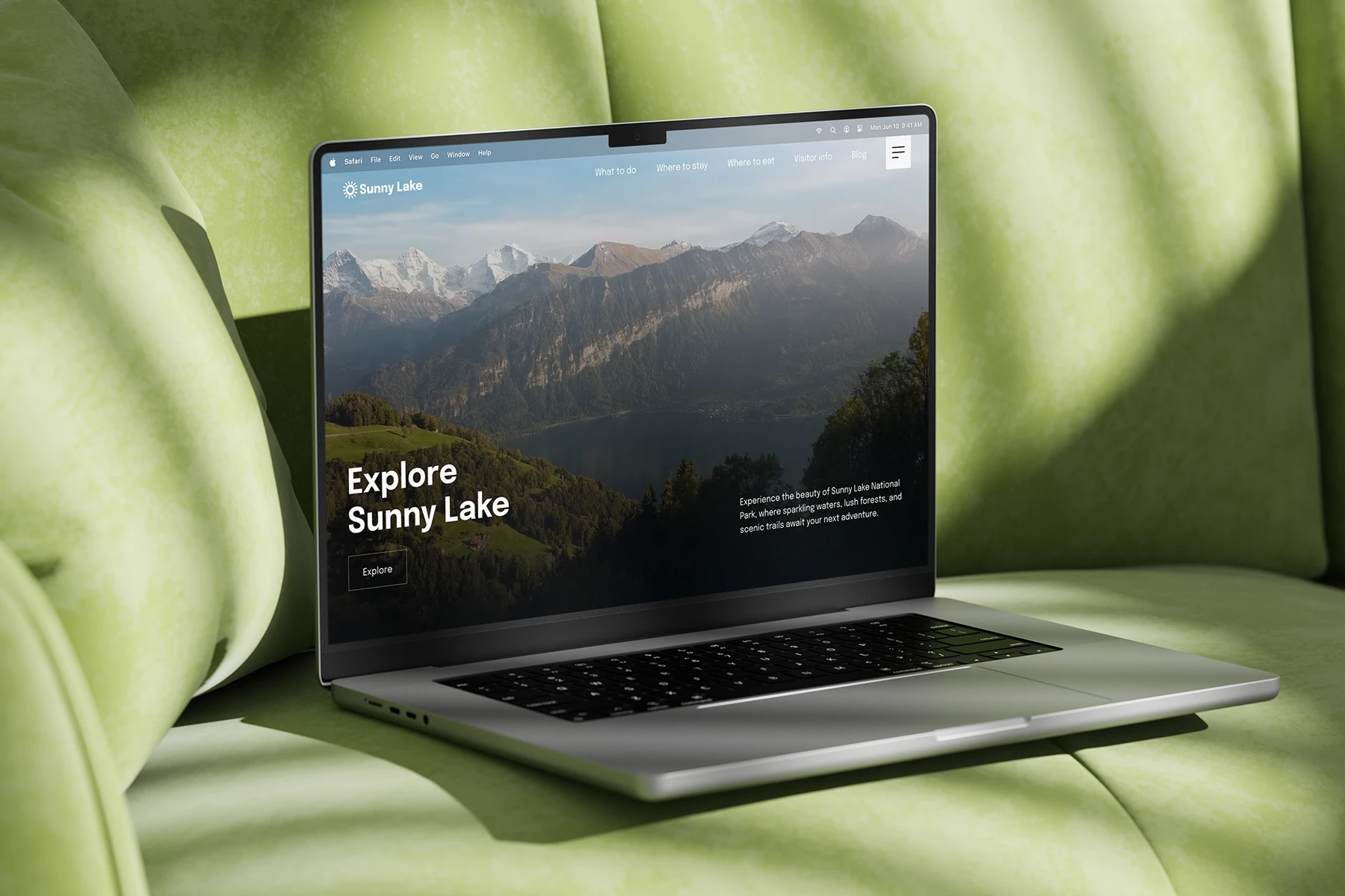 Laptop on green cushioned seat showing a website with a mountain and lake landscape titled Explore Sunny Lake.