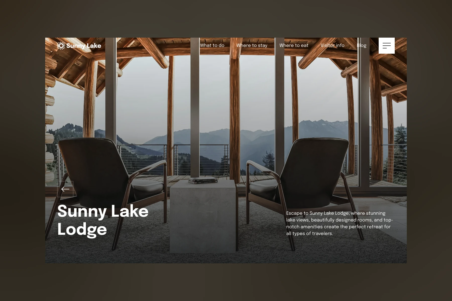 Two modern chairs facing large glass windows overlooking mountain and forest views from a wooden lodge balcony.