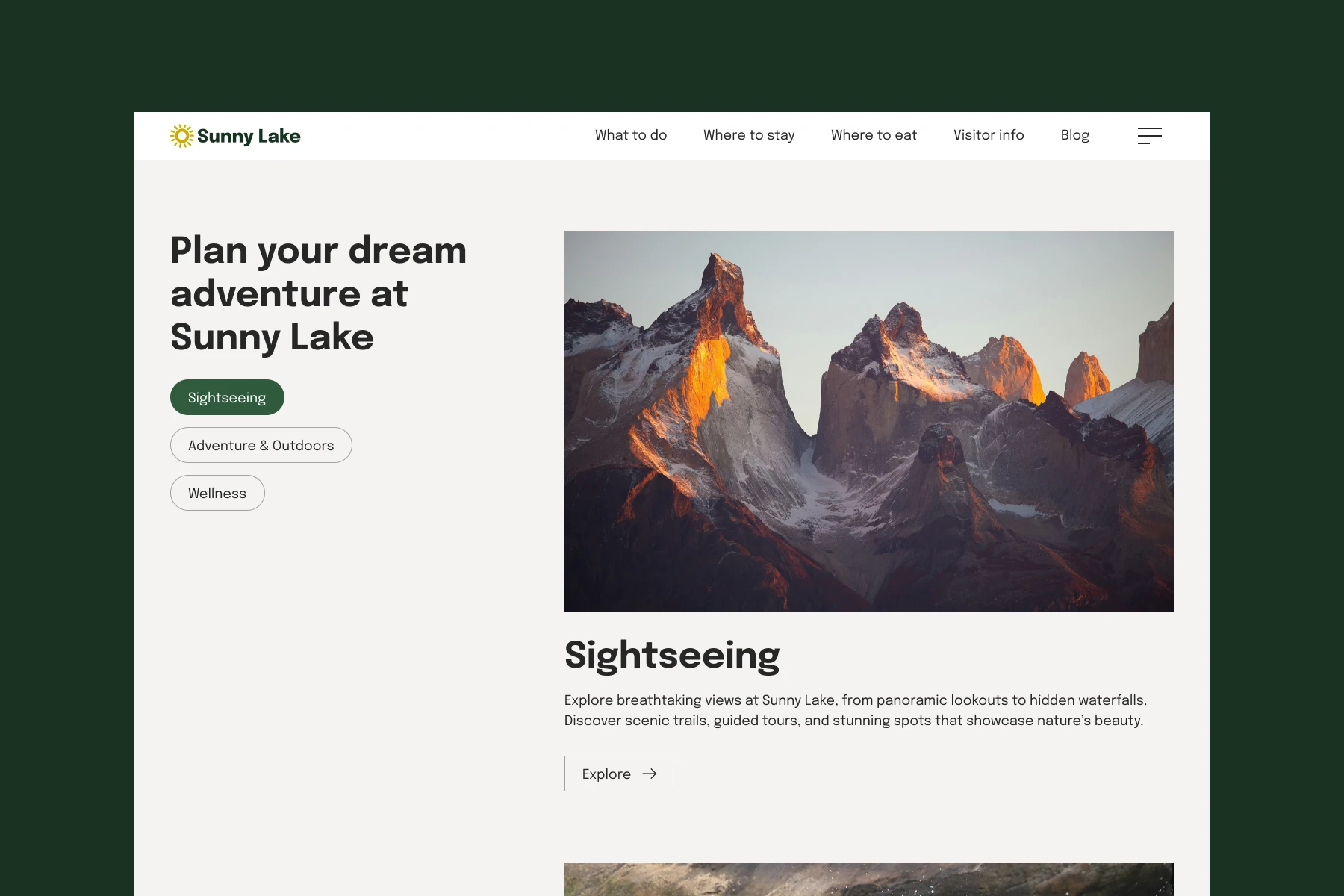 Sunlit rocky mountain peaks at sunset with snow patches against a clear sky.