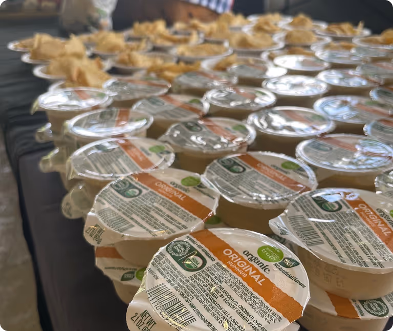 A spread of hummus containers across a table