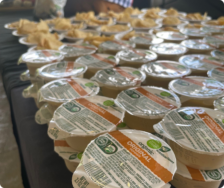 A spread of hummus containers across a table