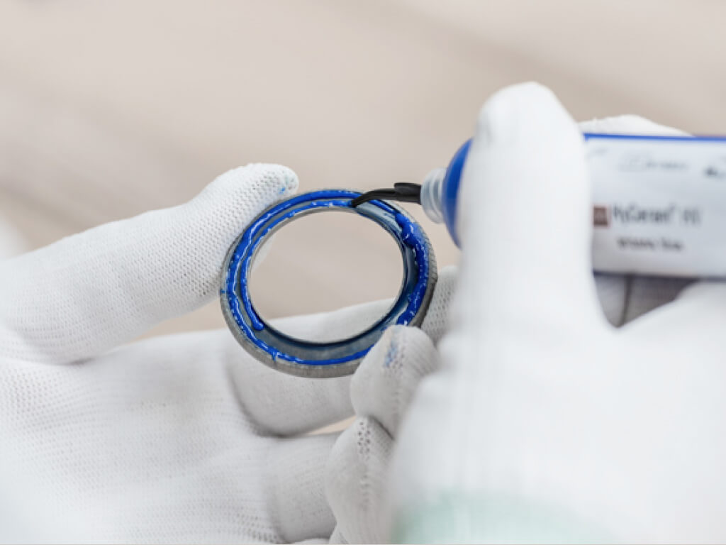 Eine Person mit weißen Handschuhen trägt eine hyceram auf.