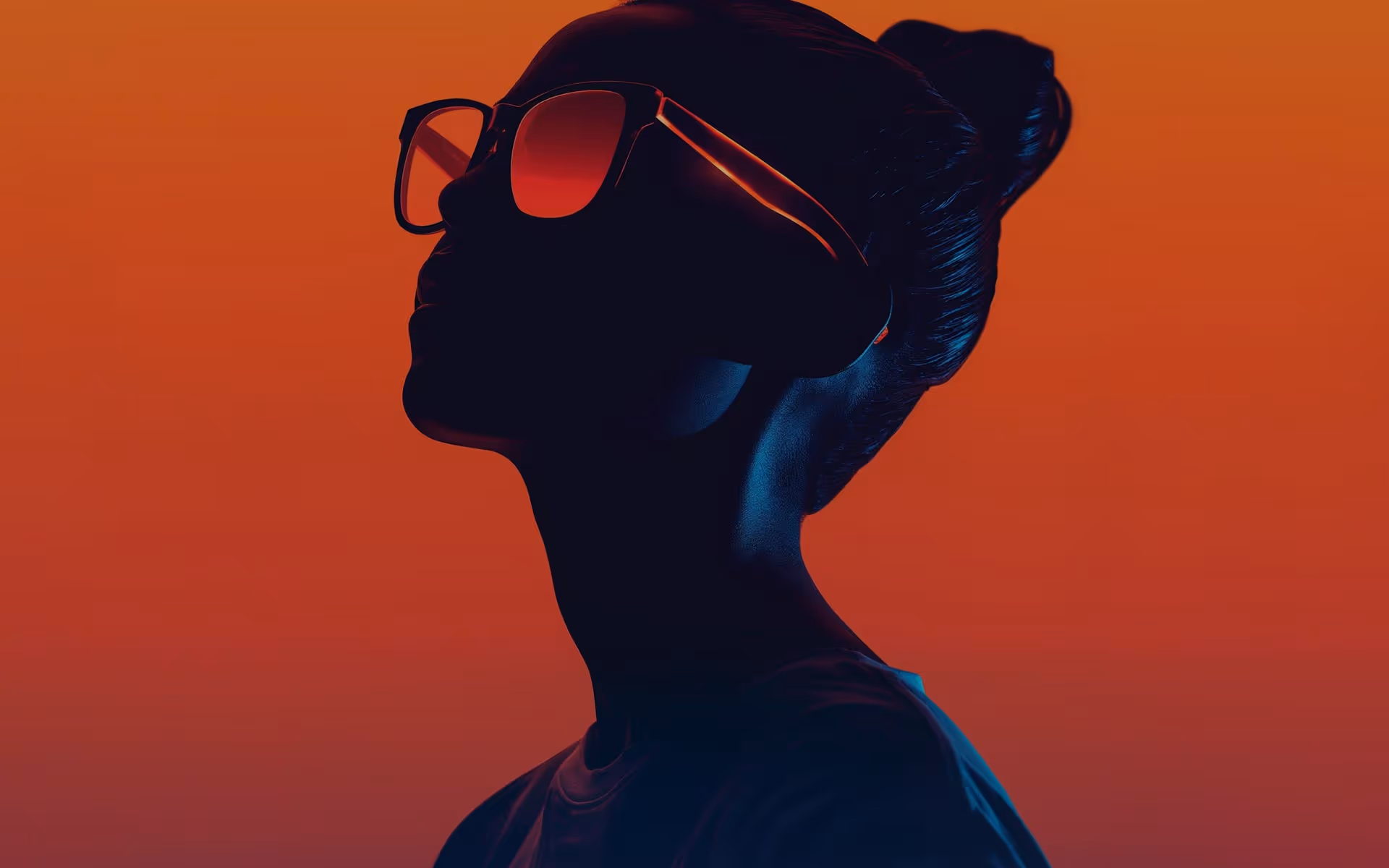 Beautiful young woman in orange glasses on orange background.