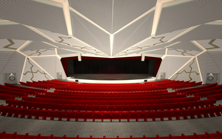 Modern auditorium with multiple rows of red seats facing a large stage with a geometric patterned ceiling and walls.