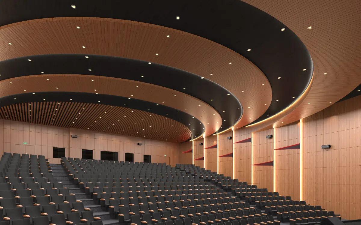 Modern auditorium with multiple rows of black chairs and curved wooden ceiling panels illuminated by recessed lighting.