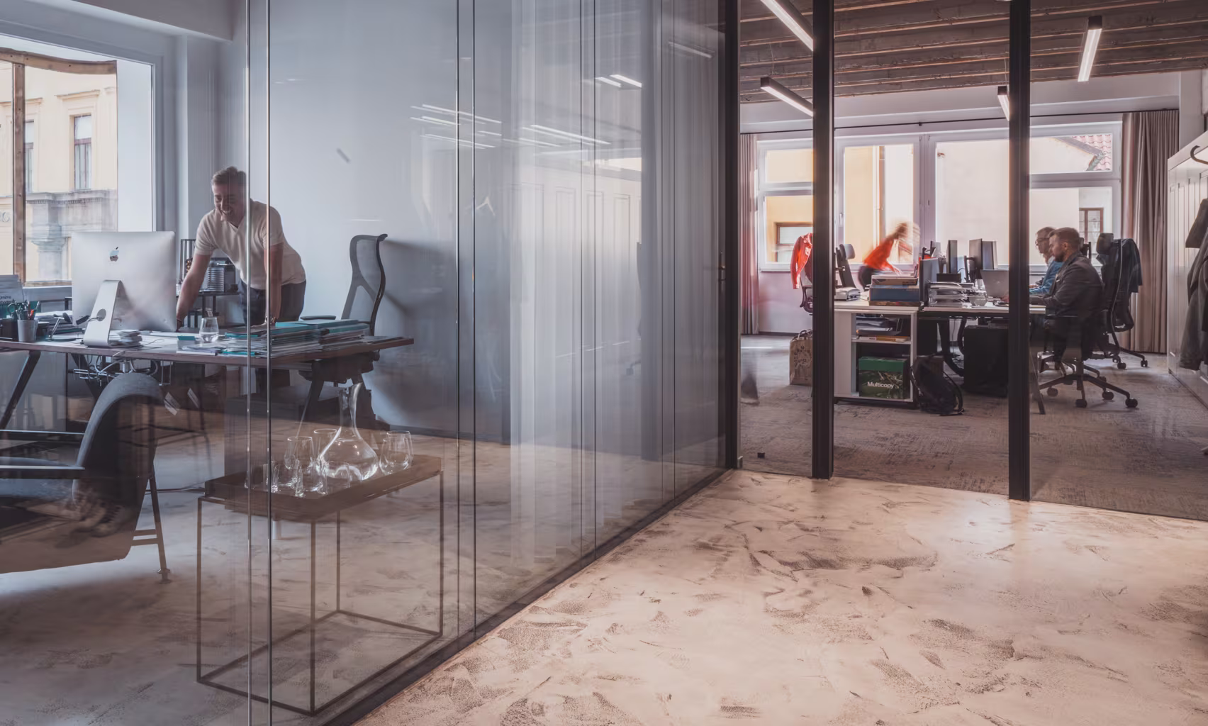 Pohled do kanceláře ZDR Investments, kde pracují lidé u svých stol. 