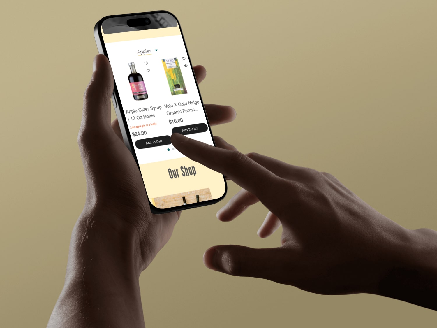 Hand holding smartphone displaying an online store page featuring apple cider syrup and organic farm products with add to cart buttons.